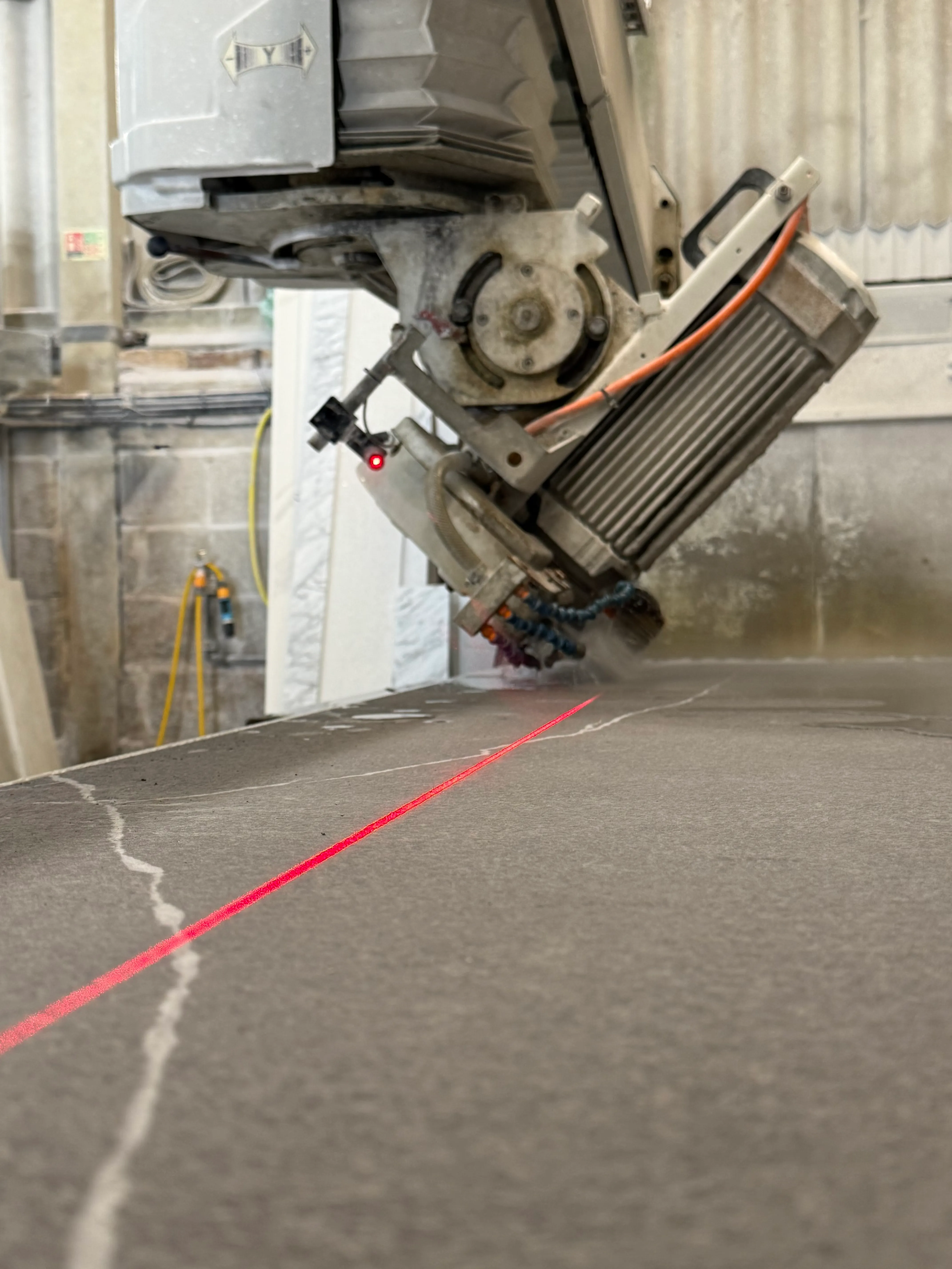 CNC bridge saw with laser guide cutting stone in our workshop
